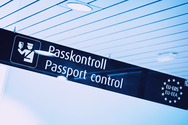 Woman handing a passport to another person at border security checkpoint