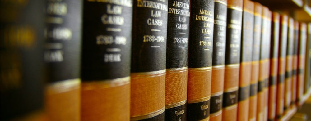 Row of law reference books with black and tan spines on a shelf.