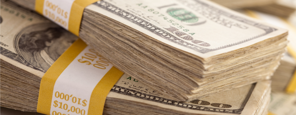 Stacks of U.S. hundred dollar bills bound with yellow paper bands.