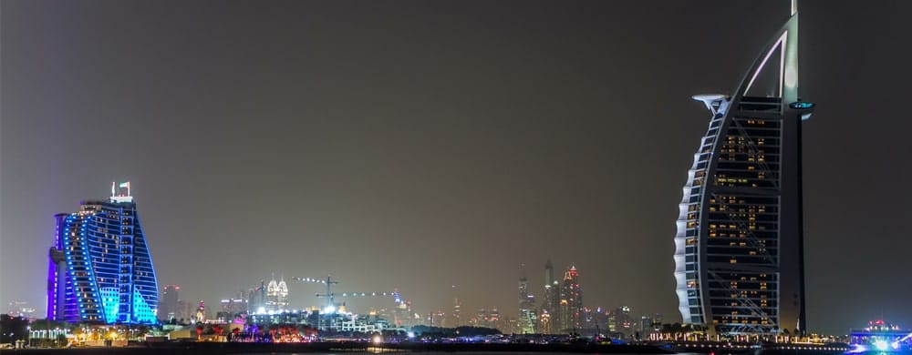 Dubai skyline at night featuring illuminated modern skyscrapers including the distinctive Burj Al.