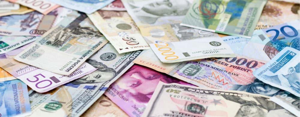 Various international banknotes including euros and US dollars scattered together.